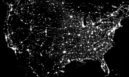 A night time view of the United States showing city lights from coast to coast.